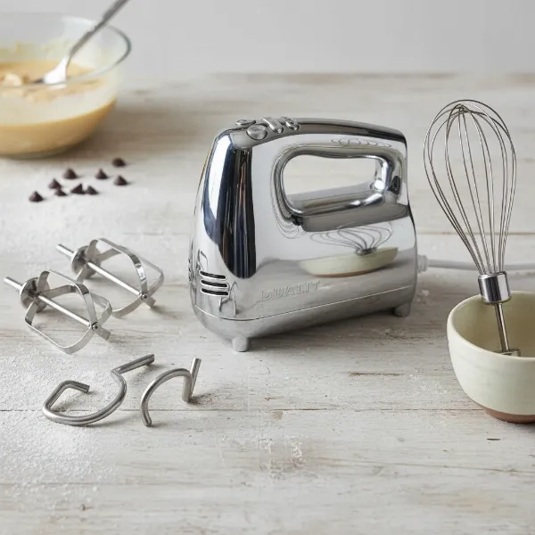 Dualit hand mixer with its various attachments: flat beaters, dough hooks, and a balloon whisk.