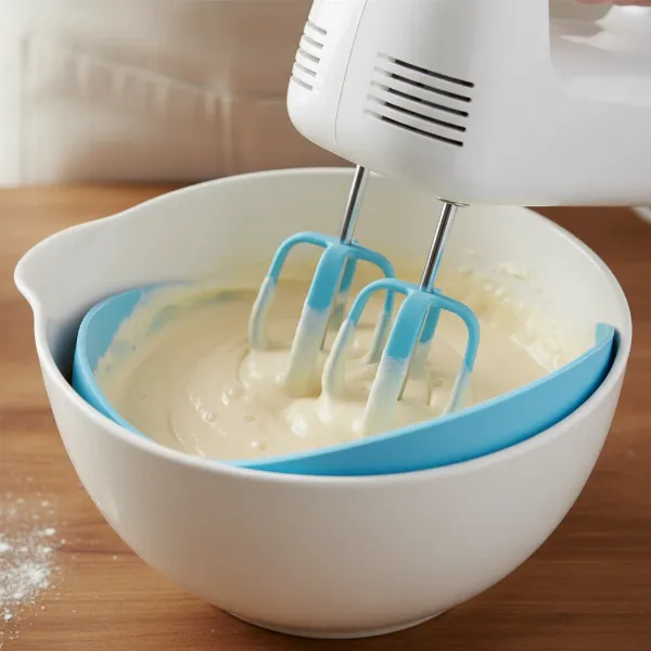 Close-up of hand mixer with silicone beaters gently mixing batter in a ceramic bowl, no scratches.