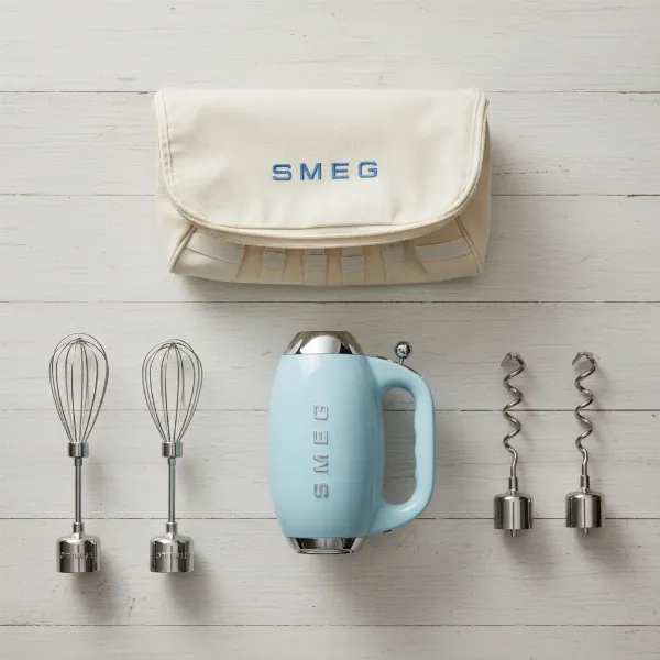 Smeg HMF01 hand mixer with all included accessories and fabric storage case neatly displayed.